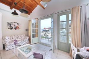 uma sala de estar com um sofá e uma mesa em Port view apartment em Skopelos Town