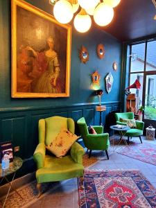 uma sala de estar com duas cadeiras e um quadro na parede em Hotel Du Cygne Tours em Tours