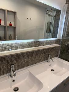 a bathroom with two sinks and a mirror at Loft sur l'eau avec parking in Paris