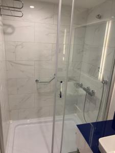 a shower with a glass door in a bathroom at Luxury Studio with Ocean View in Batumi