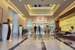 a lobby with people sitting on couches in a building at Luxury Studio with Ocean View in Batumi