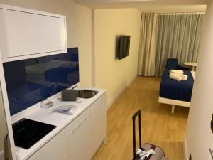 a room with a kitchen and a bedroom with a bed at Luxury Studio with Ocean View in Batumi