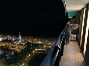 a woman standing on the ledge of a building at Luxury Studio with Ocean View in Batumi