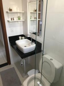 een badkamer met een wastafel en een toilet bij Praia Castelhanos - ES in Anchieta