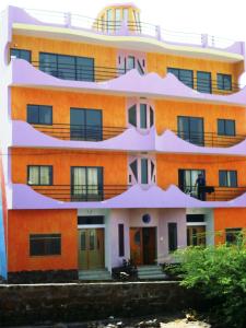 een oranje gebouw met balkons aan de zijkant bij Zena Star in Tarrafal