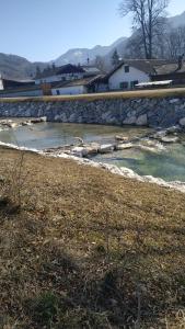 a river with a stone wall next to a field at Urlaub im schönen Nussdorf/Inn in Nußdorf am Inn