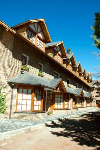 un gran edificio de ladrillo con ventanas laterales. en casas de alquiler Del Encuentro en San Martín de los Andes