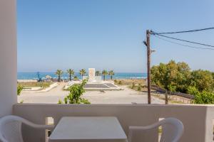 balcón con mesa y vistas a la playa en Domenica Apartments, en Rethymno