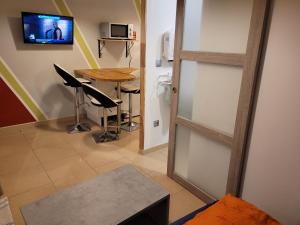 a room with a table and a door with a television at la grange in Coigneux