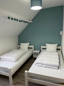 2 camas en una habitación con una pared verde en A Nous Quatre en Le Tréport