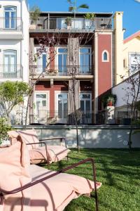 um grupo de cadeiras sentadas na relva em frente a um edifício em Jardins do Porto - by Unlock Hotels no Porto