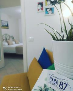 une table avec une plante dans un vase blanc sur elle dans l'établissement Casa 87 - Sorrento, à Sorrente