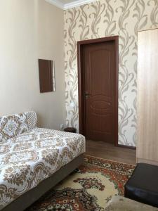 a bedroom with a bed and a door and a rug at Hostel Viator in Almaty