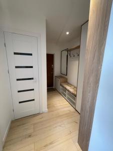 an empty room with a door and a mirror at Livinga Lovely 1-bedroom apartment in Mažeikiai
