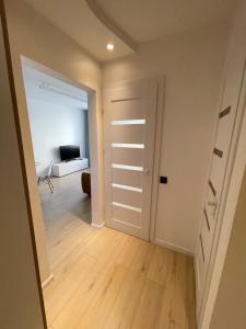 an empty room with a door leading to a living room at Livinga Lovely 1-bedroom apartment in Mažeikiai