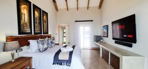 a bedroom with a large bed and a television at Seebederfie in Groot Brak Rivier