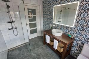 uma casa de banho com um lavatório e um espelho em Olive Tree Bed and Breakfast em Olvera