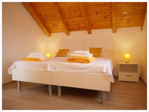 a white bed in a room with wooden ceilings at House Natalija in Podgreben