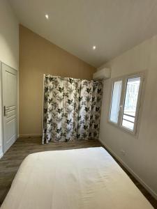 Un dormitorio con una cama grande y una ventana en Le petit cassis, en Cassis