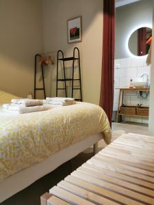 ein Schlafzimmer mit einem Bett, einem Spiegel und einem Tisch in der Unterkunft La villa Marseillanaise in Marseillan + 73 Fotos