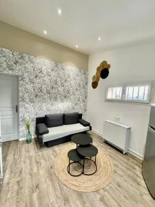 Una sala de estar con un sofá y dos taburetes. en Le petit cassis, en Cassis