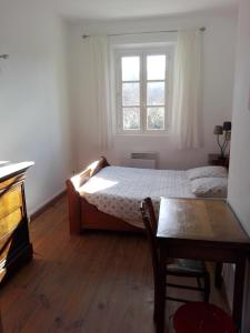 1 dormitorio con cama, mesa y ventana en Mas Bohème, en Espeluche