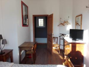 Habitación con cama, mesa y TV. en Mas Bohème, en Espeluche