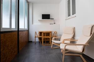 una stanza con sedie e tavolo con televisore di Entrecampos - Two bedroom apartment with Terrace a Lisbona