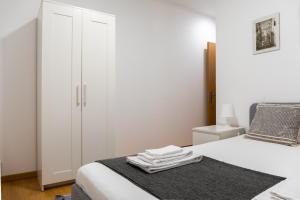 una camera bianca con un letto e un armadio di Entrecampos - Two bedroom apartment with Terrace a Lisbona