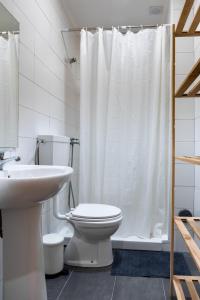 e bagno con servizi igienici e tenda da doccia bianca. di Entrecampos - Two bedroom apartment with Terrace a Lisbona
