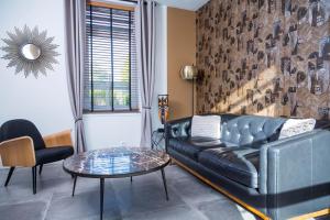 un salon avec un canapé en cuir et une table dans l'établissement Gîtes de La Vesée, à La Chapelle dʼArmentières 37 autres photos