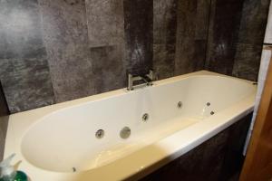 a bath tub with a faucet in a bathroom at Dovedale Hotel and Restaurant in Cleethorpes +42 photos