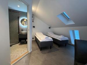 um quarto com 2 camas, um lavatório e um espelho em Torsken Brygge em Torsken