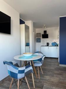 a living room with a table and chairs and a kitchen at Morza Szum in Dziwnów
