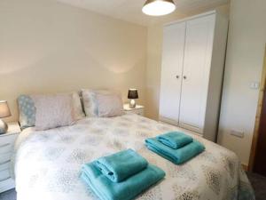 a bedroom with a bed with blue towels on it at Ty Rhos, Farm Stay, sleeps 4, Rhoshirwaun 2 miles from Aberdaron in Aberdaron