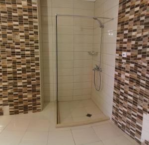 a shower with a glass door in a bathroom at Александра Палас in Kranevo