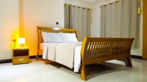 a bedroom with a bed and a bench and a window at AVIEL HOME in Accra