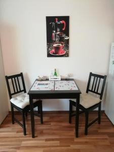 a dining room table with two chairs and a sink at Ferienappartement Ruhrtal Witten in Witten