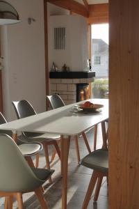 una sala da pranzo con tavolo e sedie bianchi di Ferienhaus am Burggraben a Stendal