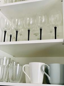 a bunch of wine glasses sitting on a shelf at Suuremõisa Holiday Apartment with Sauna in Suuremõisa