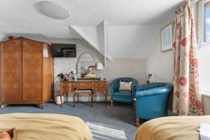 a bedroom with a desk and a blue chair at The Westgate in Torquay