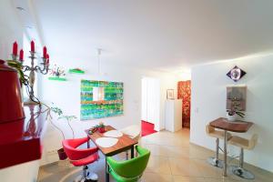 a dining room with a table and red and green chairs at Freundliche Ferienwohnung (Souterrain) mit Gartenmitbenutzung im Haus Lotus in Bad Urach