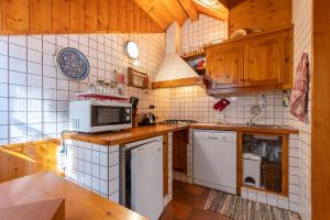 a kitchen with white appliances and wooden cabinets at Dimora Catitti in Mazzin +22 photos