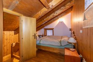 a bedroom with a bed in a room with wooden walls at Dimora Catitti in Mazzin