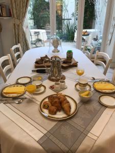 a table with food and orange juice and croissants on it at Le 31 B&B Amboise Centre in Amboise