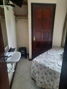 1 dormitorio con cama, lavabo y puerta en Hotel Casa Encantada, en Penedo