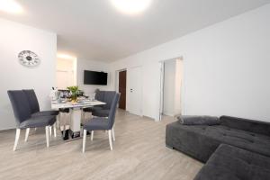 Una sala de estar con un sofá negro y una mesa. en Marin, en Čižići