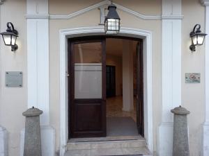 una entrada a un edificio blanco con una puerta marrón en Posada del Marques Salta en Salta