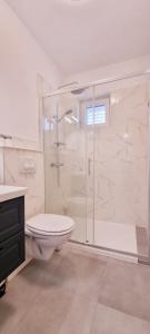 biała łazienka z prysznicem i toaletą w obiekcie Apartments Luma w Hvarze