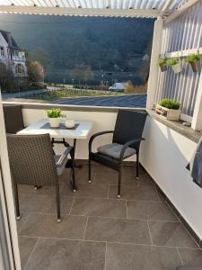 a patio with a table and chairs on a balcony at Hakans Moselblick Ferienwohnung in Treis-Karden